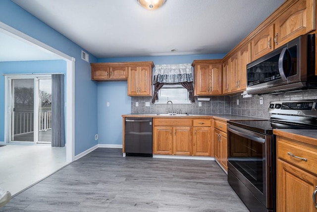 953 N Hickory Dr, Tonganoxie, KS 66086 - kitchen with electric range, dishwasher, a sink, brown cabinets, and backsplash
