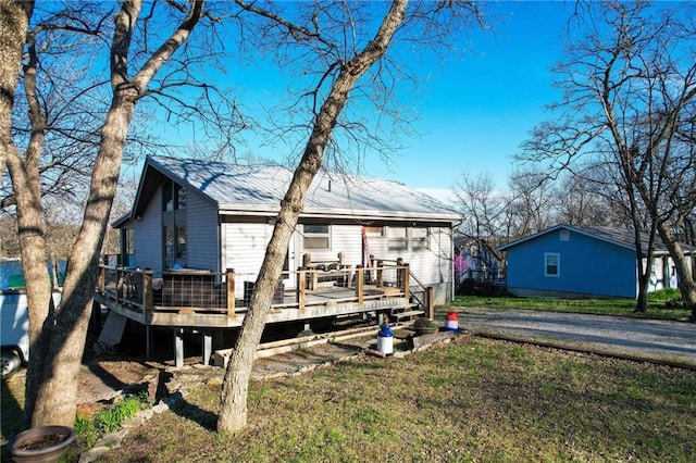 exterior space with a yard, a deck, and metal roof
