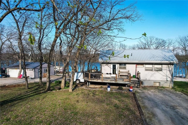 view of front of home with a front yard, a deck, and metal roof