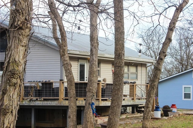 rear view of house featuring a wooden deck