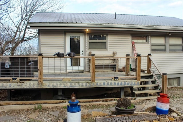 back of house with a wooden deck and metal roof