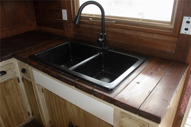details featuring tile countertops and a sink