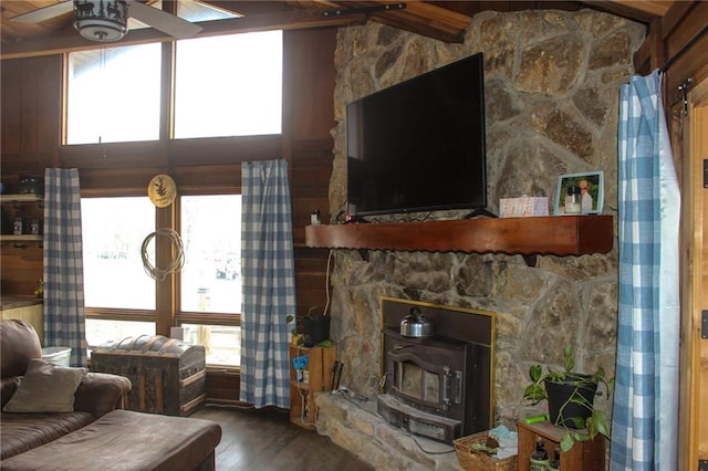 living room with a wood stove, wood finished floors, and ceiling fan