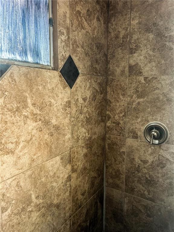 interior details featuring tiled shower