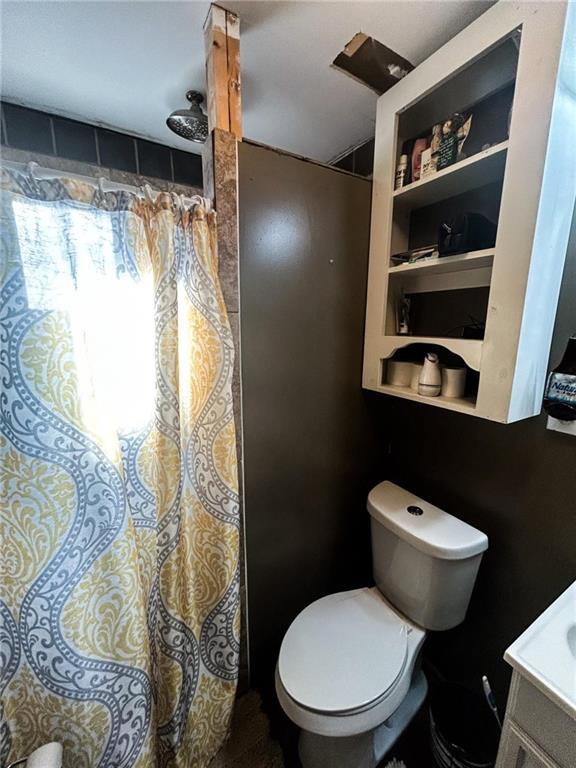 full bath with a shower with shower curtain and toilet