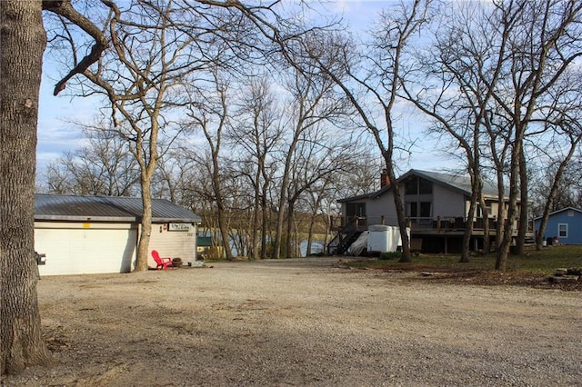 view of yard with driveway, a garage, and a deck