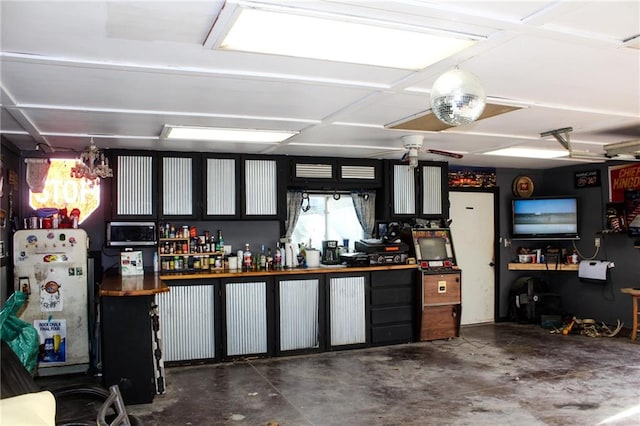 garage with freestanding refrigerator and a workshop area