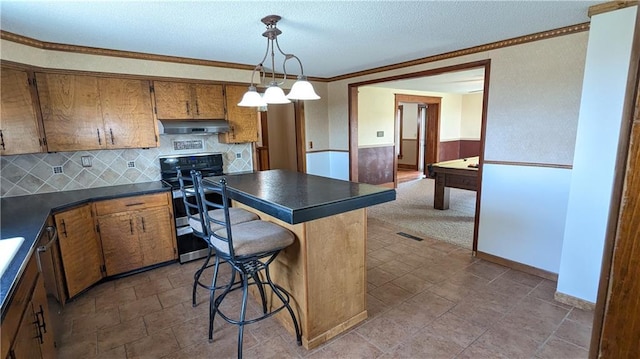 2023 Linden Rd, Hiawatha, KS 66434 - kitchen featuring dark countertops, ornamental molding, under cabinet range hood, and range with two ovens