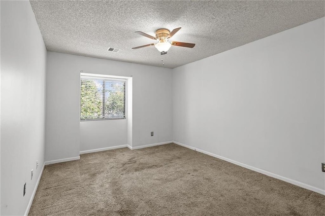 spare room with ceiling fan, carpet, a textured ceiling, and baseboards