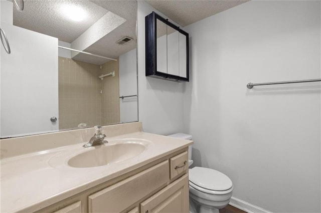 full bath featuring toilet, a textured ceiling, a shower, and vanity