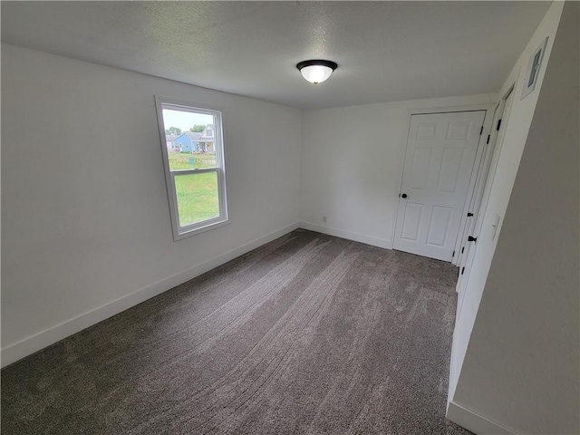 6211 Washington St, Saint Joseph, MO 64504 - unfurnished room featuring baseboards, dark carpet, and a textured ceiling