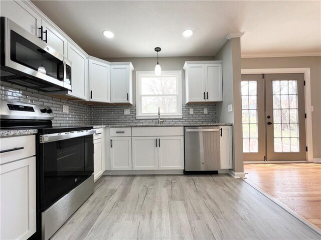 kitchen featuring a wealth of natural light, decorative backsplash, a sink, and stainless steel appliances
