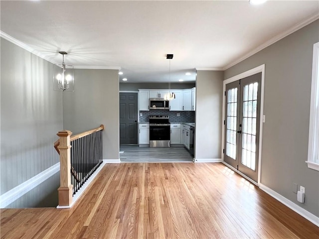 unfurnished living room with baseboards, light wood-type flooring, and crown molding