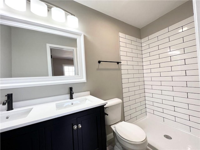 full bath featuring toilet, a sink, double vanity, and a shower stall