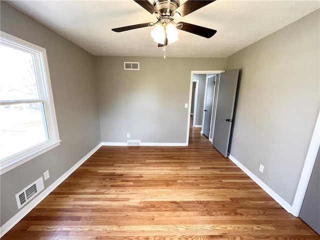 unfurnished bedroom featuring multiple windows and visible vents