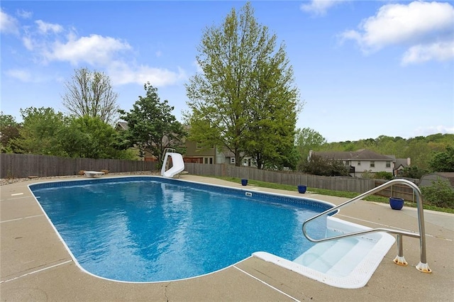 view of swimming pool featuring a fenced in pool, a fenced backyard, and a water slide