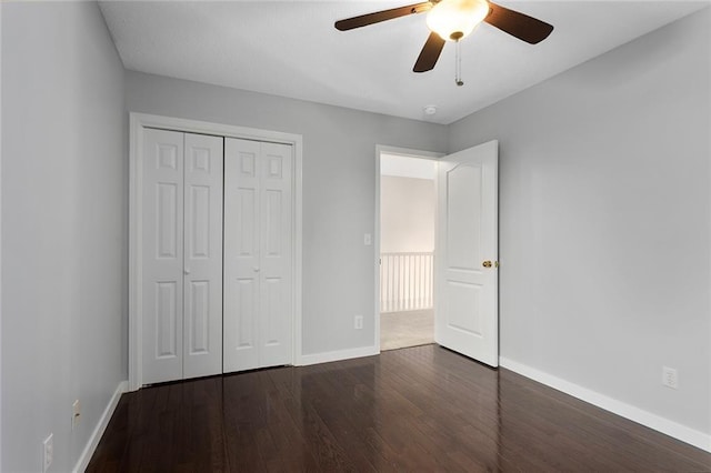 unfurnished bedroom with baseboards, ceiling fan, wood finished floors, and a closet
