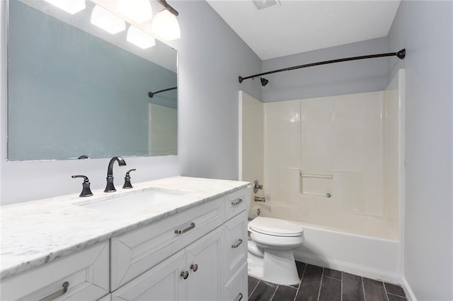 bathroom featuring wood finish floors, vanity, toilet, tub / shower combination, and visible vents