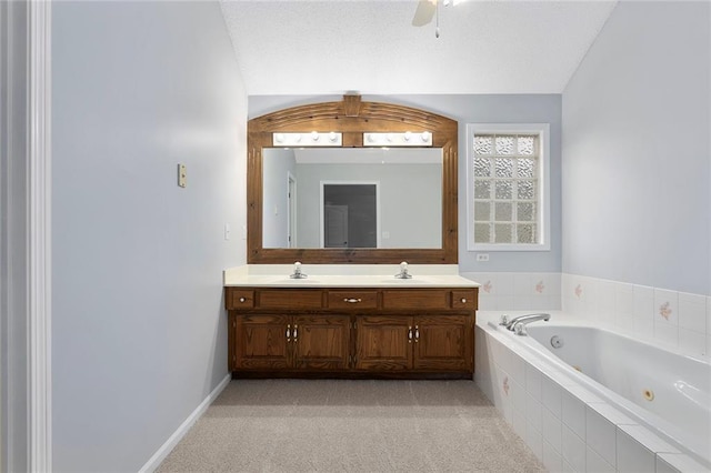 bathroom with a sink, ceiling fan, a jetted tub, and double vanity