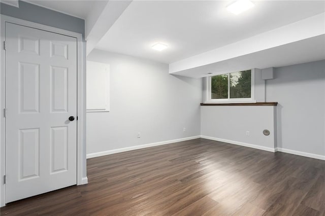 below grade area with baseboards and dark wood-style floors