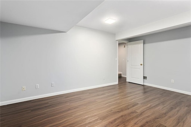 finished below grade area with baseboards and wood finished floors