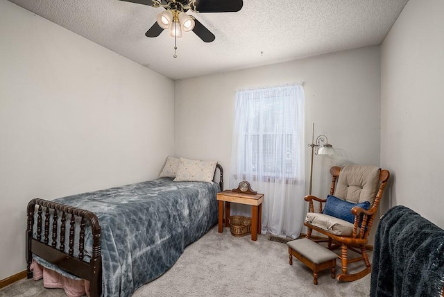 bedroom featuring a textured ceiling, a ceiling fan, and carpet