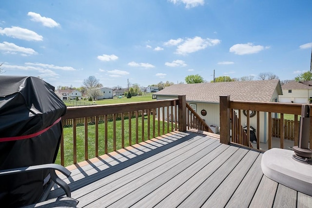 wooden deck featuring a yard, a residential view, and area for grilling