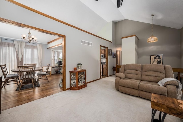 carpeted living area featuring baseboards, visible vents, a notable chandelier, and vaulted ceiling