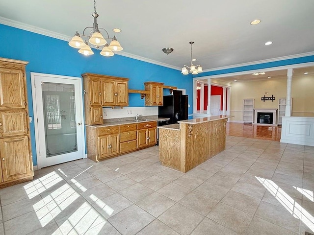 kitchen with an inviting chandelier, light countertops, light tile patterned floors, and freestanding refrigerator