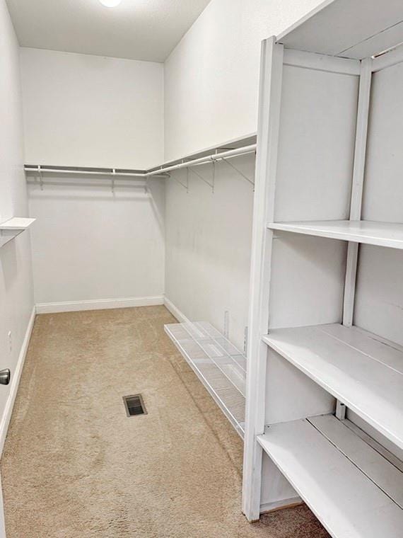 spacious closet featuring visible vents and carpet floors