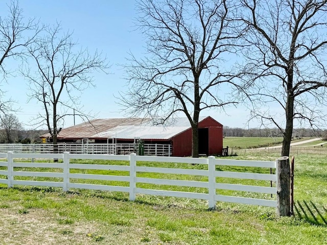 view of gate featuring a rural view, an exterior structure, and an outdoor structure