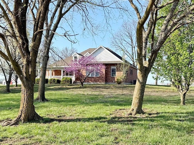 view of front facade with a front yard and brick siding