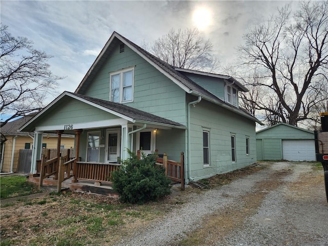 1126 S Pearl St, Independence, MO 64050 - view of front of home with gravel driveway, an outdoor structure, a porch, and a garage