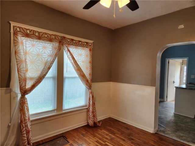 1126 S Pearl St, Independence, MO 64050 - spare room with arched walkways, ceiling fan, and wood finished floors