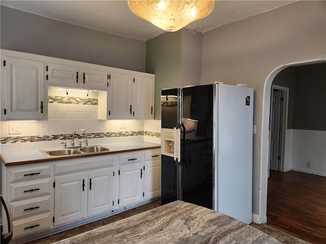 1126 S Pearl St, Independence, MO 64050 - kitchen featuring white cabinets, decorative backsplash, a sink, and black fridge