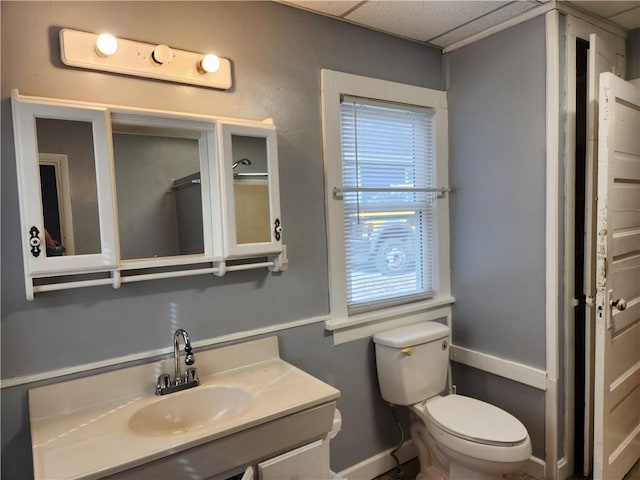 1126 S Pearl St, Independence, MO 64050 - bathroom featuring toilet, vanity, baseboards, and a paneled ceiling