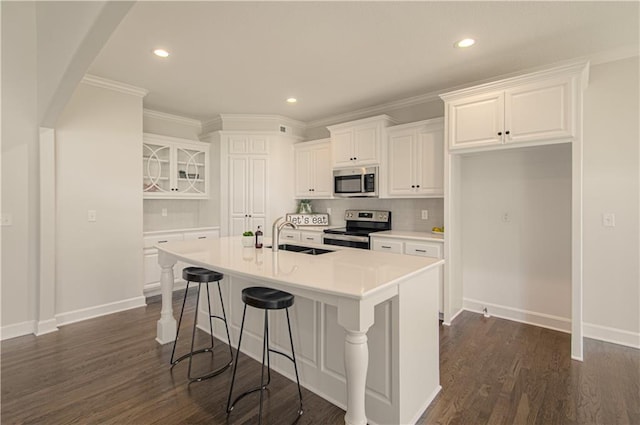 kitchen featuring white cabinets, decorative backsplash, a sink, and stainless steel appliances