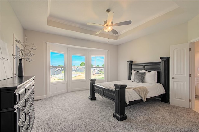 bedroom with a raised ceiling, light carpet, crown molding, and ceiling fan