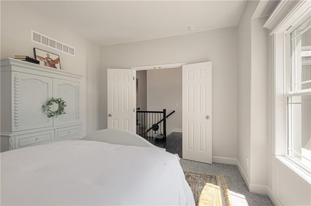 carpeted bedroom with baseboards and visible vents