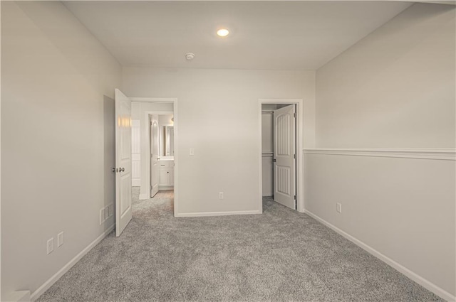 unfurnished bedroom with recessed lighting, carpet flooring, a spacious closet, baseboards, and visible vents