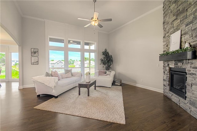 living room featuring ornamental molding, a healthy amount of sunlight, a fireplace, and ceiling fan