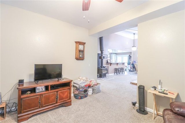 1404 S Market St, Holden, MO 64040 - carpeted living area with ceiling fan, a wood stove, and baseboards