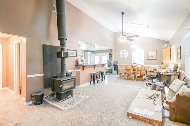 1404 S Market St, Holden, MO 64040 - carpeted living room with a wood stove, ceiling fan, and high vaulted ceiling