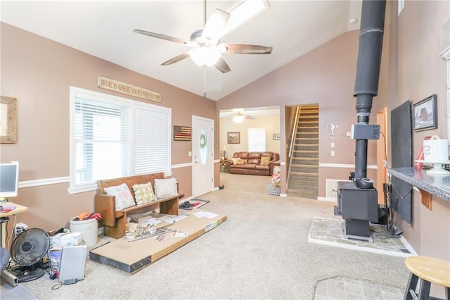 1404 S Market St, Holden, MO 64040 - living room with a wood stove, ceiling fan, lofted ceiling, carpet flooring, and stairway
