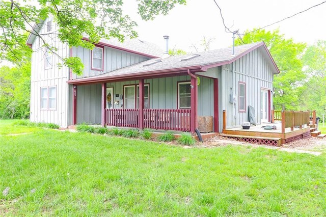 1404 S Market St, Holden, MO 64040 - back of property with board and batten siding, a porch, and a lawn