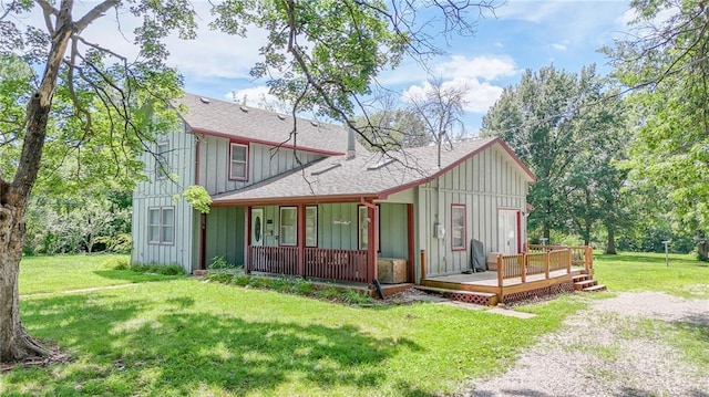 1404 S Market St, Holden, MO 64040 - back of property with board and batten siding, roof with shingles, a yard, and covered porch