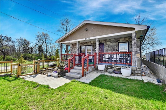 2705 Endicott Ave, Kansas City, KS 66104 - back of house with stone siding, a porch, stucco siding, and a yard