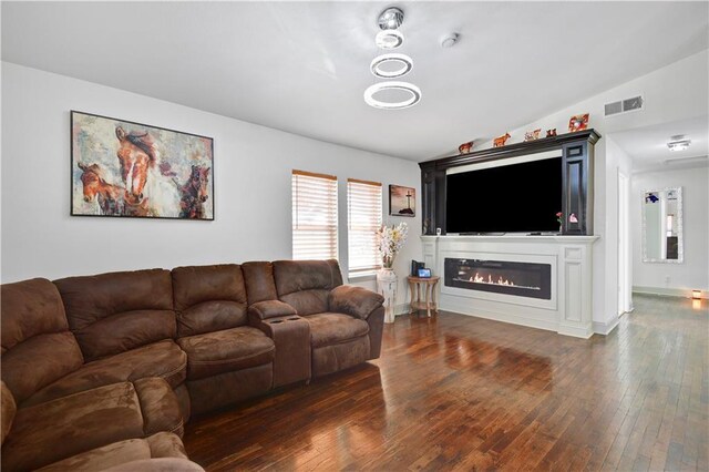 2705 Endicott Ave, Kansas City, KS 66104 - living area featuring visible vents, baseboards, lofted ceiling, a glass covered fireplace, and wood-type flooring