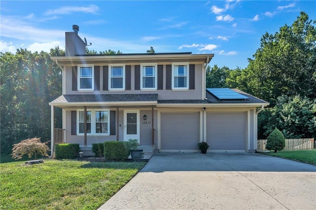 view of front of property with fence, roof mounted solar panels, a chimney, a front yard, and driveway