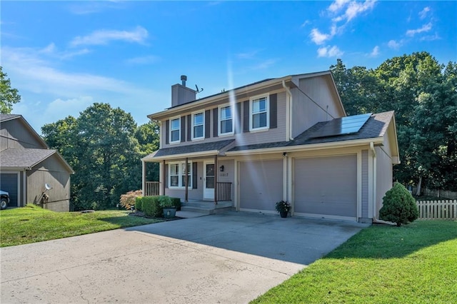 view of front of house featuring a front lawn, concrete driveway, a porch, and roof mounted solar panels